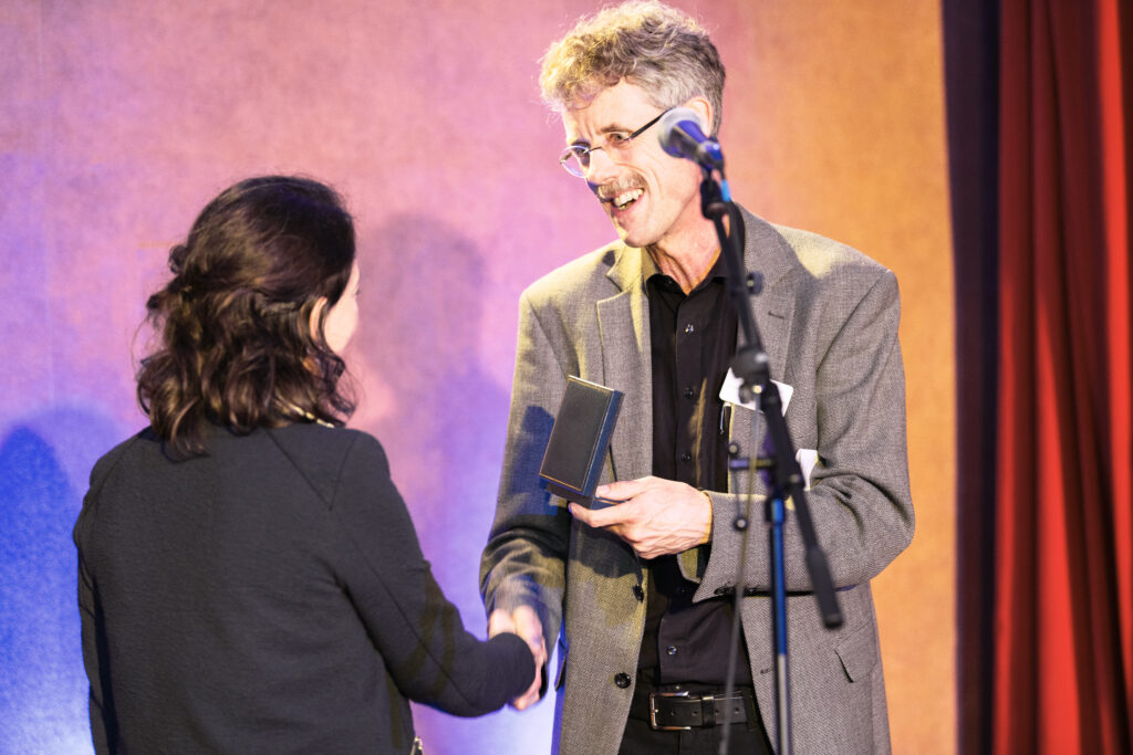 Das Bild zeigt die Verleihung des Hans-Rost-Preises an einen Preistragenden.