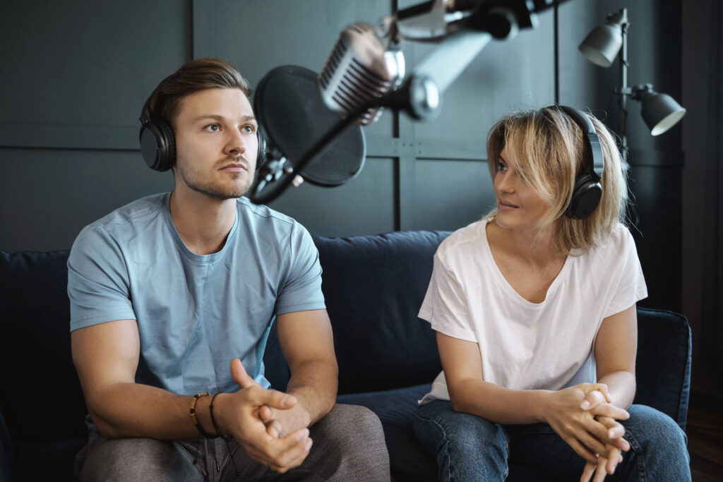Das Bild zeigt zwei Menschen bei der Medienarbeit, der Erstellung eines Podcasts.